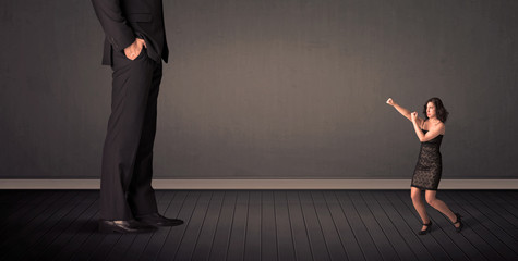 Obraz premium Little bussineswoman in front of a giant boss legs concept