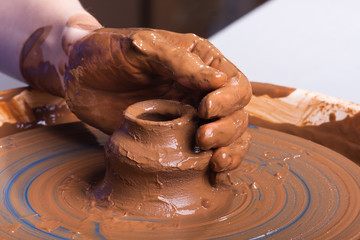 hand of potter with clay jug