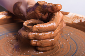 hand of potter with clay pot on pottery wheel