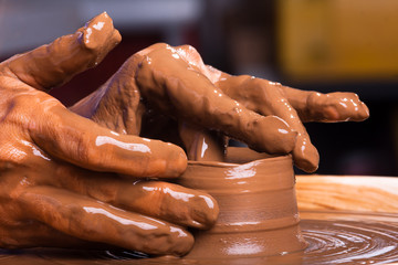 Hands of a potter, creating a clay jug