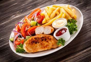Fried chicken fillet, chips and vegetable salad