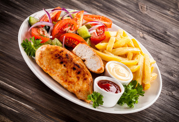 Fried chicken fillet, chips and vegetable salad