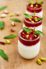 Homemade milk dessert with raspberry jam and pistachio nuts
