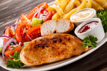 Fried chicken fillet, chips and vegetable salad