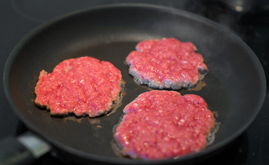 Ground beef patties in the pan.