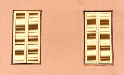 Fototapeta premium Two window with yellow shutters. Close-up view.
