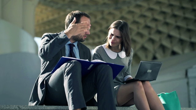 shocked businesspeople working with laptop, documents on stairs