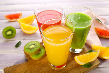 Fresh juices with fruits on wooden table