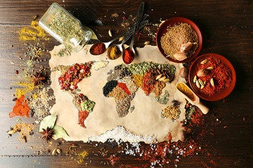 Map of world made from different kinds of spices on wooden background