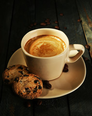 Cup of coffee and tasty cookies on wooden background