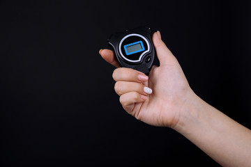 Electronic sport timer in  female hand on black background