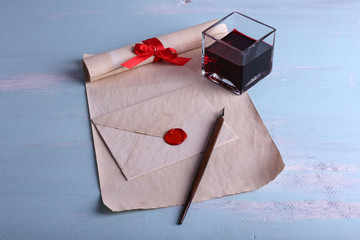 Envelope with pen and ink on wooden background