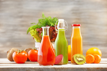 Fototapeta na wymiar Glass bottles of fresh healthy juice with set of fruits and
