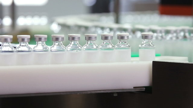 Bottles with drugs on conveyor in pharmaceutical factory