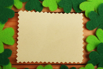 Greeting card for Saint Patrick's Day with shamrocks on wooden planks background