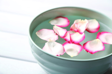 Fototapeta na wymiar Rose petals in bowl on wooden background