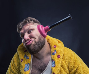 Strange man with a plunger in his ear
