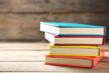 Colorful notebooks on old wooden table