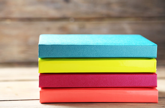Colorful notebooks on old wooden table