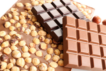 Black and milk chocolate bars with hazelnuts close up