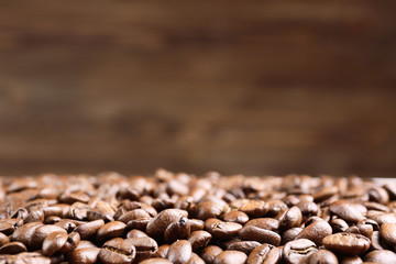 Naklejka premium Coffee beans on brown background