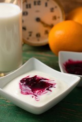 Mixed fruit in white yogurt on green worn table