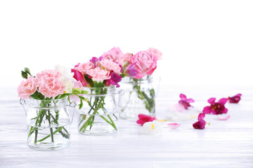 Beautiful spring flowers in glass bottles isolated on white