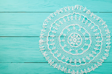 Lace doily on wooden background