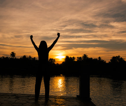 The success concept of silhouette of Young woman standing arms made Under the Rising Sun