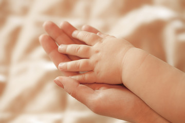 Obraz na płótnie Canvas Children's hand lies on a hand mother