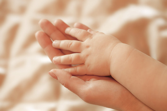 Children's hand lies on a hand mother