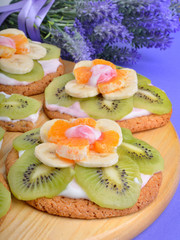 Fruit dessert with exotic fruits and lavender flowers