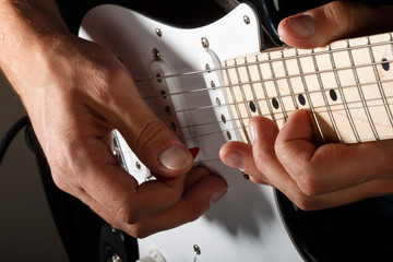 Hands of man playing electric guitar closeup