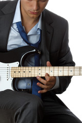 Man in suit and tie playing electric guitar