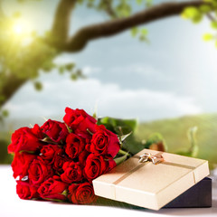 Rosen und Geschenkbox vor Frühlingshintergrund