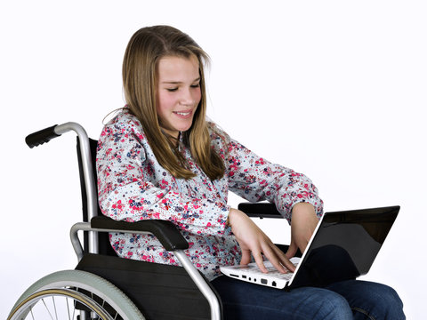Girl sat in a wheelchair with a portable computer