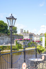 antique street lamp and cafe view of kilkenny castle - obrazy, fototapety, plakaty
