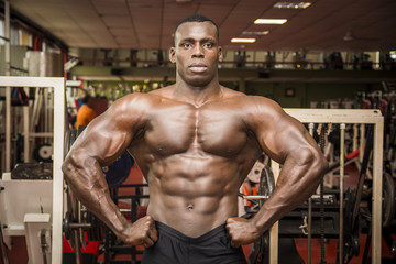 Fototapeta na wymiar Handsome black male bodybuilder posing in gym