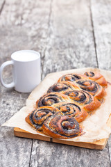 Poppy seed roll freshly baked on th table with mug of milk