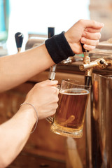 Fototapeta na wymiar Barman pours fresh beer into the glass