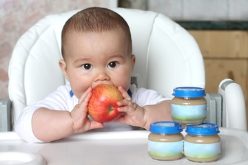 Baby with apple and puree at bank