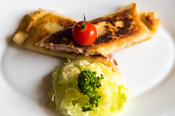 closeup crepes with ham and cheese on a plate