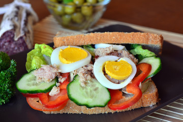 Rye bread sandwich with tuna fish, tomato and cucumber slices