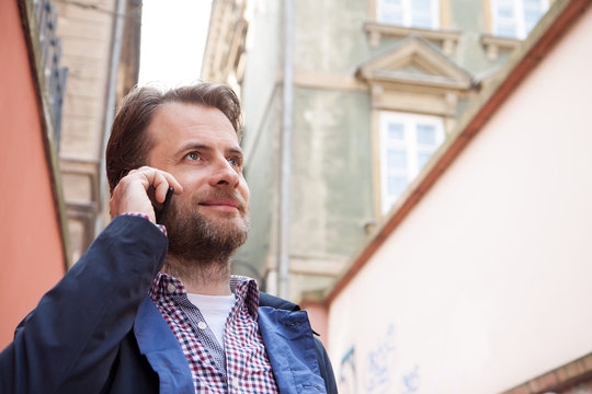 Close up portrait of smiling man talking on a mobile phone