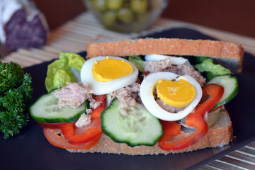 Rye bread sandwich with tuna fish, eggs, tomato and cucumber