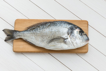 Fresh dorado fish on wooden cutting board