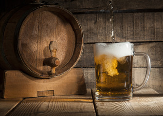 Beer barrel with beer mug on wooden background