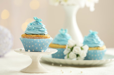 Delicious cupcakes on table on light background
