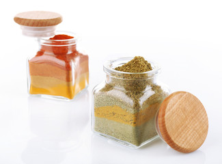 Different kinds of spices in glass bottles isolated on white