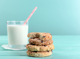 Tasty cookies and glass of milk on color wooden background